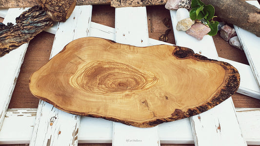 olive wood with sharp edges with bark, with organic shape of the trunk. nice rustic kitchen board